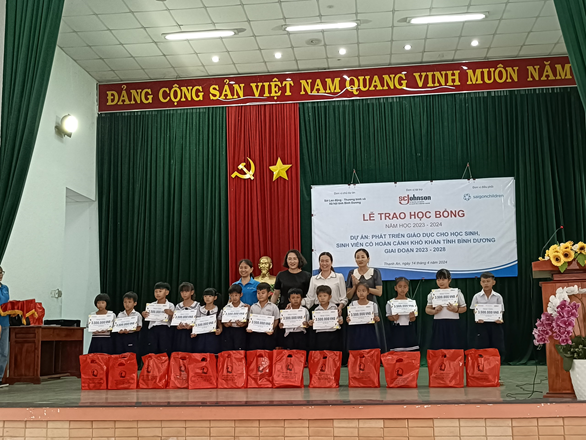 Bà Nguyễn Ngọc Hằng – Phó giám đốc Sở Lao động – Thương binh và Xã hội tỉnh Bình Dương và các đại biểu, nhà tài trợ trao học bổng cho trẻ em có hoàn cảnh khó khăn huyện Dầu Tiếng